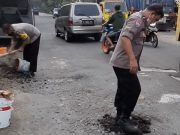 Anggota Polsek Godong Tambal Jalan untuk Cegah Kecelakaan