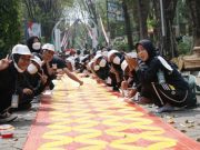 7.255 Mahasiswa Baru UNS Pecahkan Rekor Muri Warna Kain Pola Batik Sepanjang 3.300 Meter