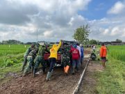 Satgas TMMD Bersama Warga Dorong Mobil Material yang Terjebak dalam Lumpur