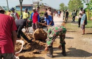 Satgas TMMD dan Warga Berjibaku Pecahkan Bongkahan Tanah Padas Guna Pengurukan Bahu Jalan